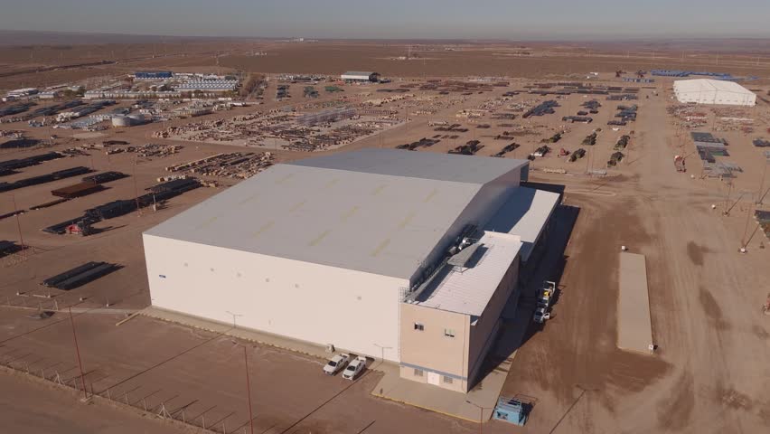 Aerial view of warehouse in expansive desert, showcasing industry growth
