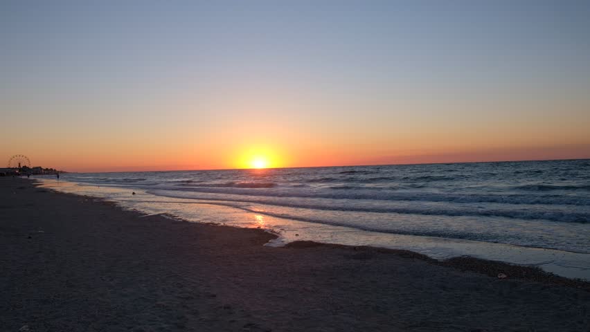 Beautiful sunrise over the Azov Sea in Kyrylivka, Ukraine
Scenic view of the sun rising above the horizon. Calm sea water and sandy beach during the golden hour in summer.