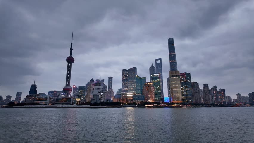 Shanghai, China: Tilt down footage of the famous Shanghai skyline facing the skyscrapers of Pudong financial district at dusk in China. Shot from the famous Bund promenade