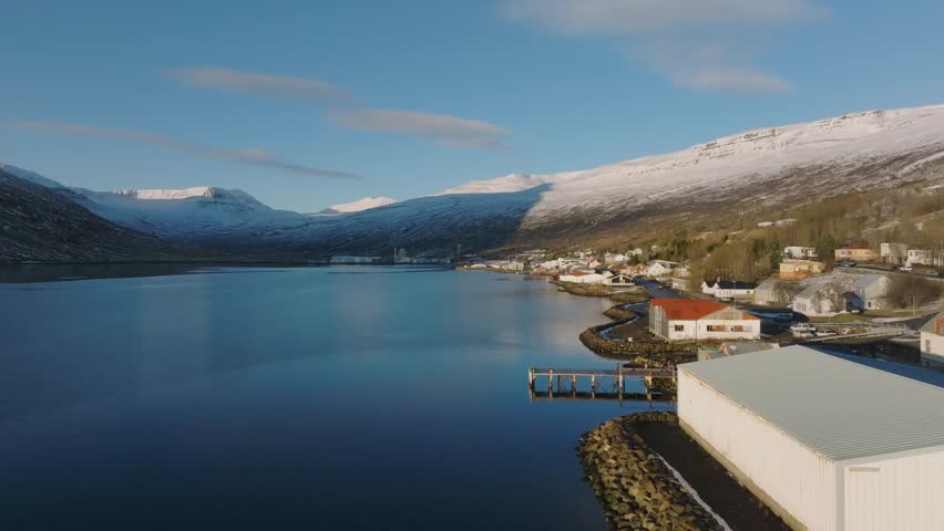 Golden hour sunset over Eskifjordur, winter landscape in Icelandic fjord - aerial