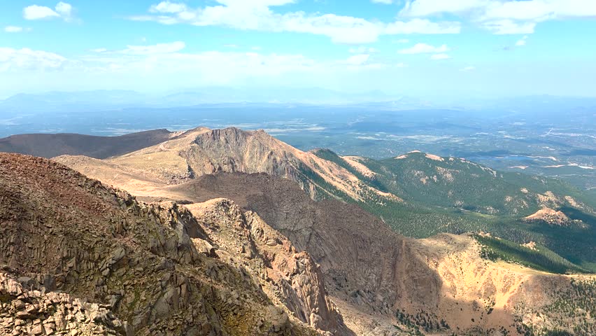 Pikes Peak mountain range in Colorado, USA, offering a wide panoramic vista of rugged terrain and distant plains, highlighting the natural beauty and grandeur of the Rocky Mountains