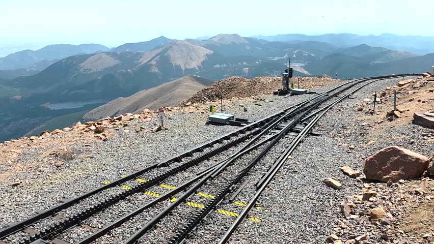 Broadmoor Manitou and Pikes Peak Cog Railway tracks with a switch high on Pikes Peak in the Colorado Rocky Mountains, panoramic view of rugged landscape and sky, USA