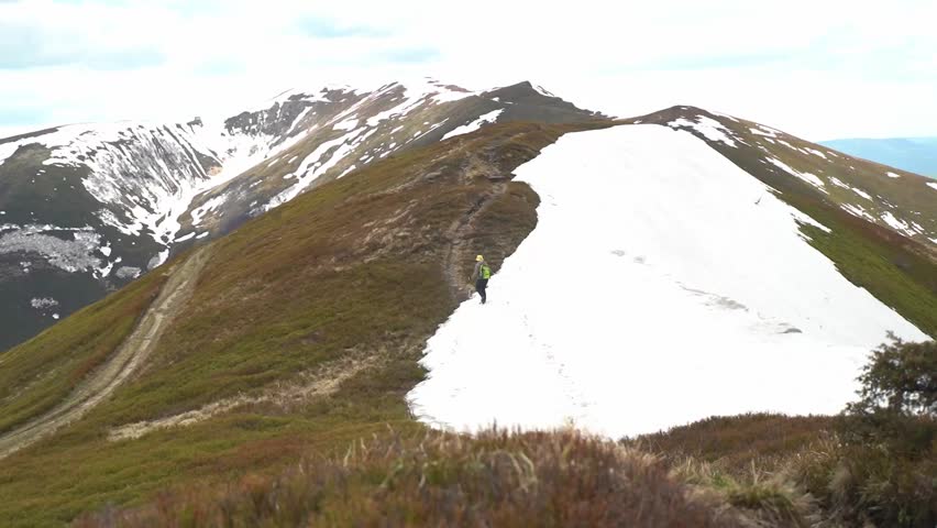 Hiking on a mountain trail with snow in the background. Spring Hiking in Carpathian Mountains, Ukraine. Borzhava range