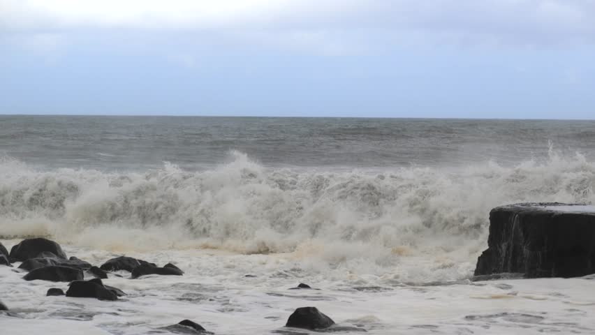 Epic crashing oceanic waves in rocky coastal shore in slow motion