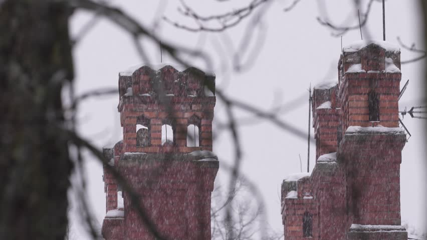 Owl winter snowfall, urban wildlife. Tawny Owls, Strix aluco, sitting in orange brick chimney on the roof. Bird in the town habitat, Białowieża in Poland. Europe wildlife. Animal in the town.