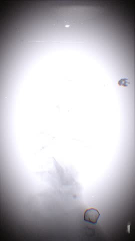 A looping background of stop motion style love grungy paper love hearts in a stylised negative film reel style.
