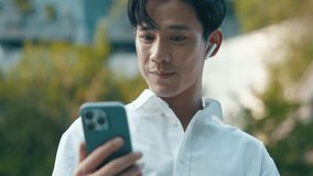 Smart young Asian businessman using smartphone for high-speed 6G video call or online meeting in a modern city. Future technology, wireless communication, and digital connectivity concept. - Powered by Shutterstock - Get 15% off with code: PIKWIZARD15
