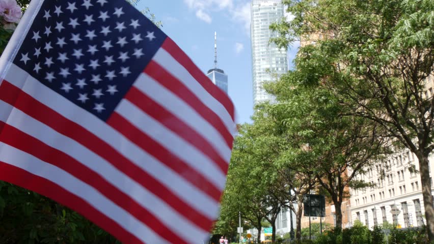 Lower Manhattan Downtown Financial District, New York City, United States. World Trade Center skyscraper building, Freedom tower, Battery park. Summer trees greenery on West street. American USA flag.