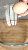 Woman's hands breaking a fresh egg with a knife into a glass bowl - Powered by Shutterstock - Get 15% off with code: PIKWIZARD15