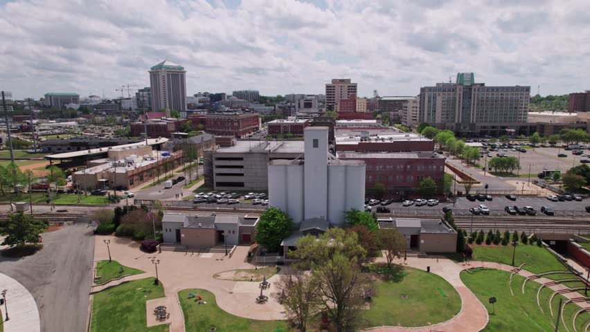 Drone shot wide aerial shot of downtown cityscape of capital city Montgomery, Alabama in deep south of America, including government buildings, riverfront, residential apartments, and car traffic