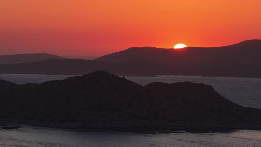 Sun setting over Rodos Greece mountains and tranquil sea
