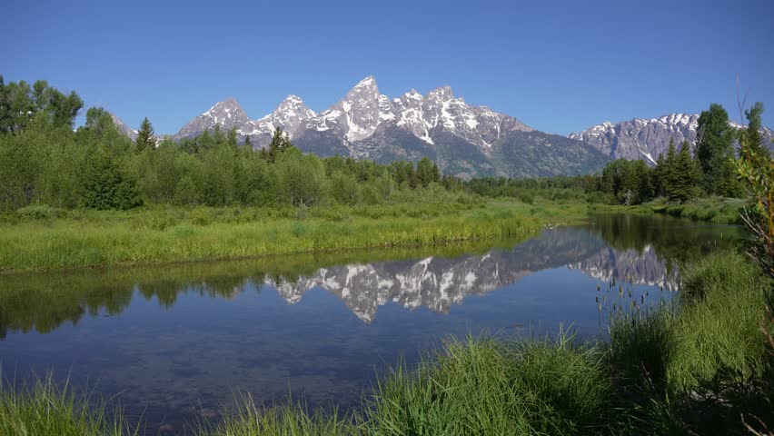 Grand Teton Mountains beautifully reflected in calm water at Grand Teton National Park, Wyoming.
