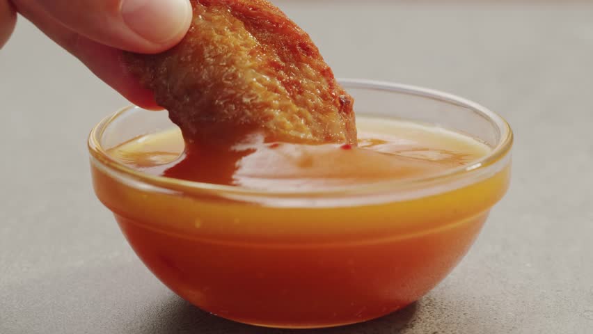 Curry cheese lemon sauce close up, fast food cafe Pouring fries potato and fry chicken in mayo yellow creamy cheese sauce close-up. Eat chicken nuggets with Peruvian sauce. Fast and junk food concept.