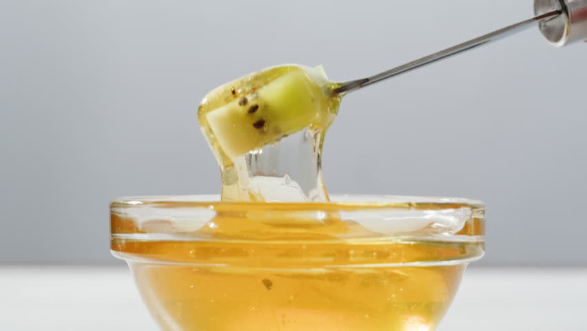 Honey macro, Tasty blue cheese with rosemary, honey and walnuts on white table, close up of Dorblu in cafe pouring in honey.