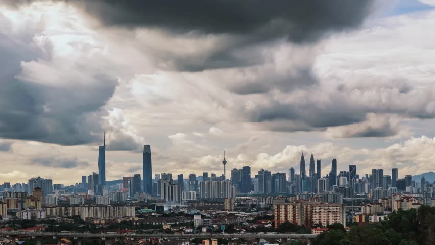 Kuala Lumpur skyline under dramatic storm clouds at day time lapse