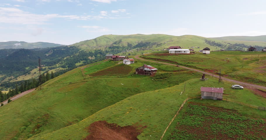 Cinematic drone footage of Goderdzi Pass summer pastures. Traditional wooden huts in the mountains.