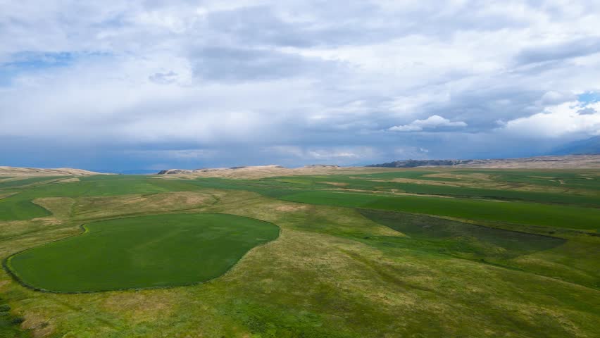 green fields at the foot of the mountains. a mountain plateau