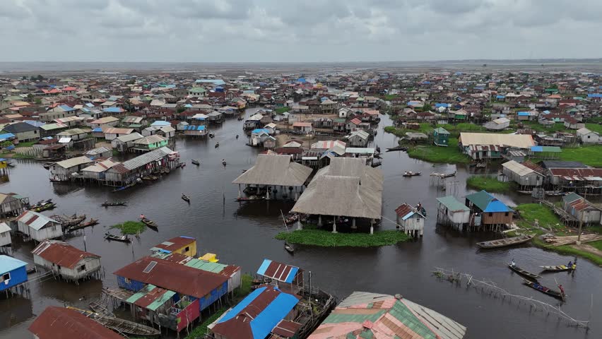 A wide aerial perspective of Ganvie, the largest floating village in Africa, showcasing the dense network of stilt houses and canals