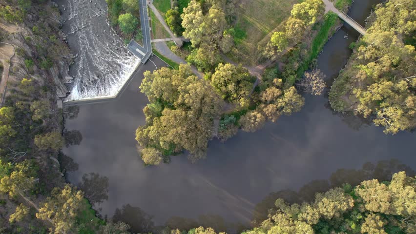 Static drone view at sunset looking straight down at Dights Falls, where Merri Creek flows into the Yarra River In Abbotsford, Melbourne, Victoria, Australia. December 2025