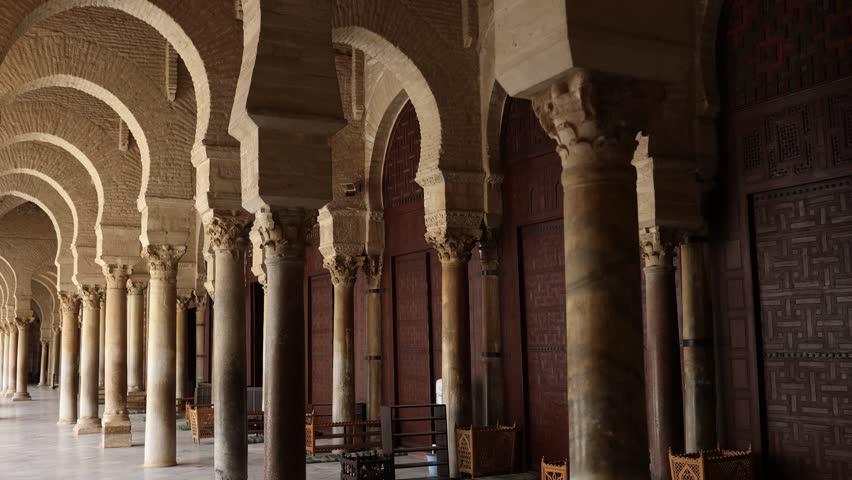Long corridors under vaulted ceiling in ancient mosque of Kairouan in Tunisia. Colonnade in patio of Islamic temple. Religious Islamic building, place of worship prayer for many generations of Muslims