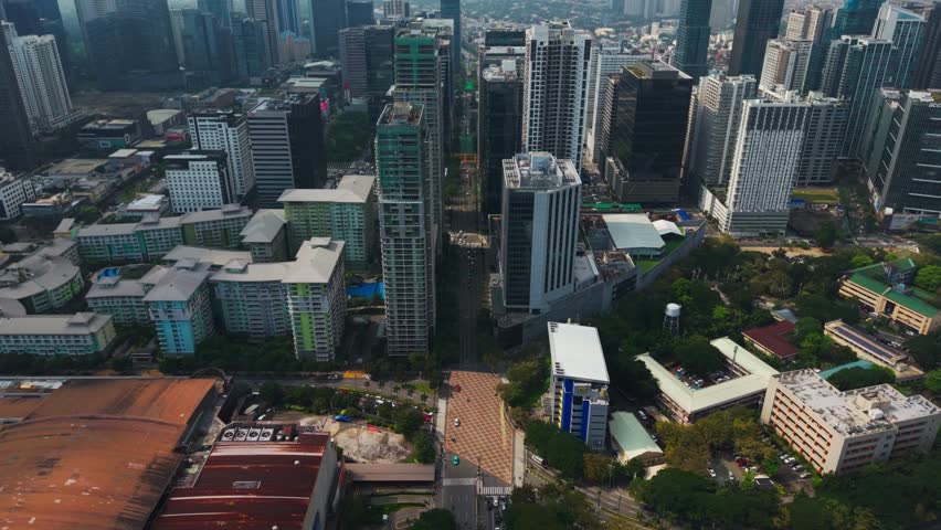 Cinematic aerial shows Bonifacio Global City skyline and morning traffic
