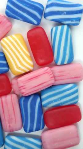 Hands close-up cutting a piece of pink soap with a craft knife over a stack of multi-colored soap, into pieces. Soft crackling and crunchy ASMR cutting sounds.