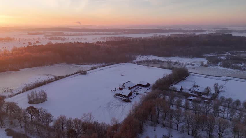 Aerial view of snow-covered rural landscape at sunrise