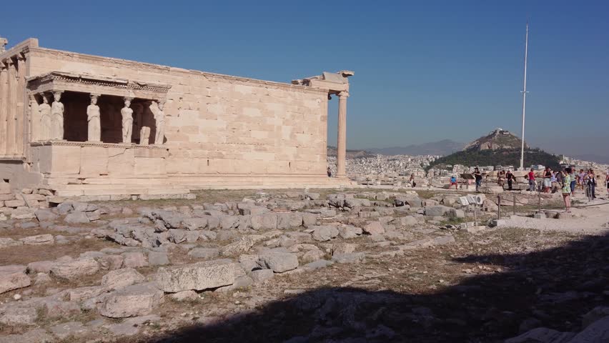 Historic Greek Architecture of Erechtheum Site in Athens Displaying Iconic Stone Column Under Clear Blue Sky Background