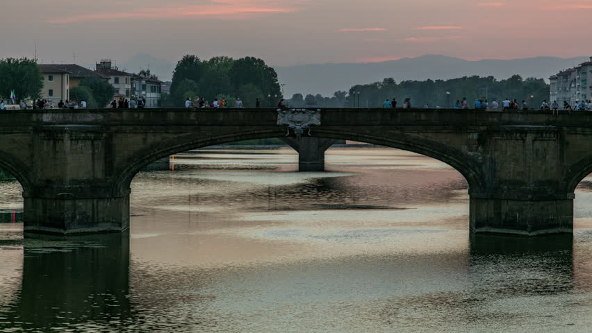 Twilight scene of Ponte Santa Trinita (Holy Trinity Bridge) day to night transition timelapse over River Arno with reflections on water after sunset. Close up view. Florence, Tuscany, Italy