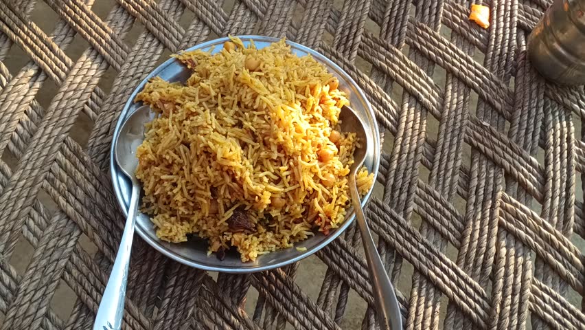 Homemade chicken biryani served on a plate, traditional South Asian rice dish recorded in natural light.
