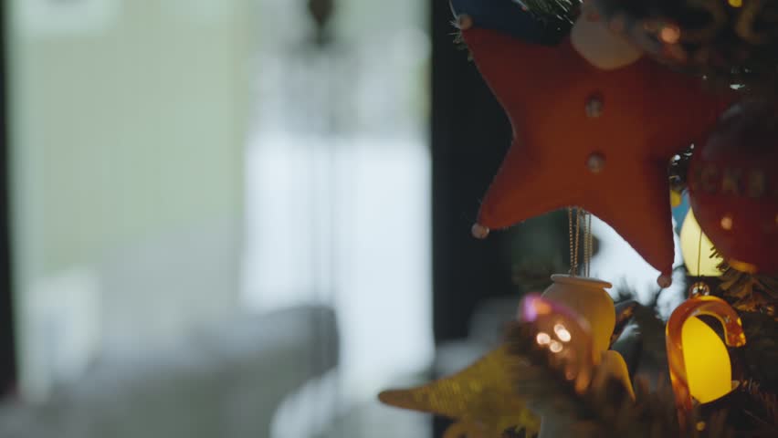 Yellow Christmas light on a decorated tree.