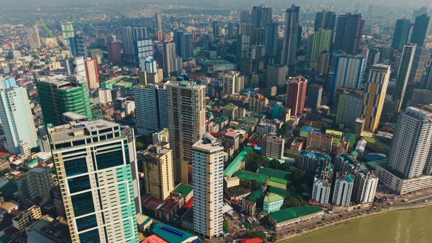 Aerial tilt movement, colorful skyscrapers of Binondo in bright light, Manila