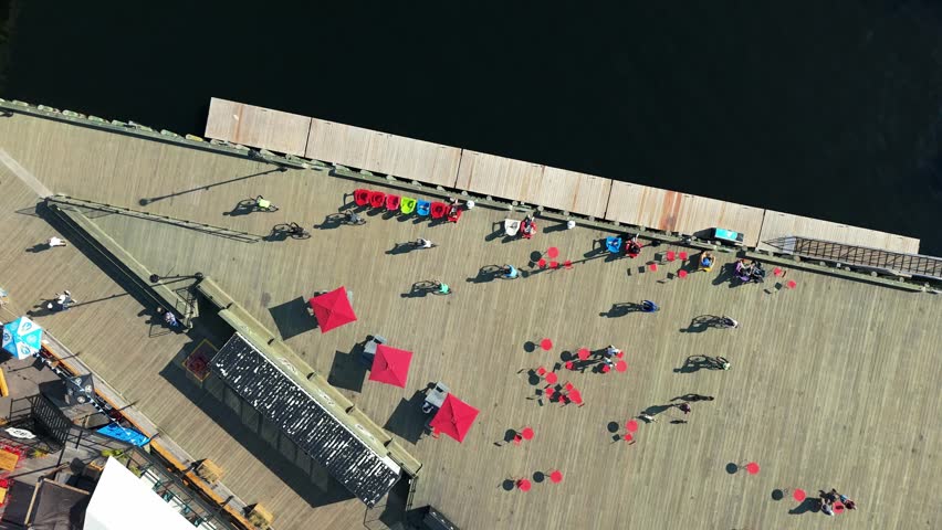 Aerial view shows group of cyclists near the Halifax marina. Beautiful mix of ocean water, historic buildings, and active tourism by the sea in the capital of Nova Scotia. 