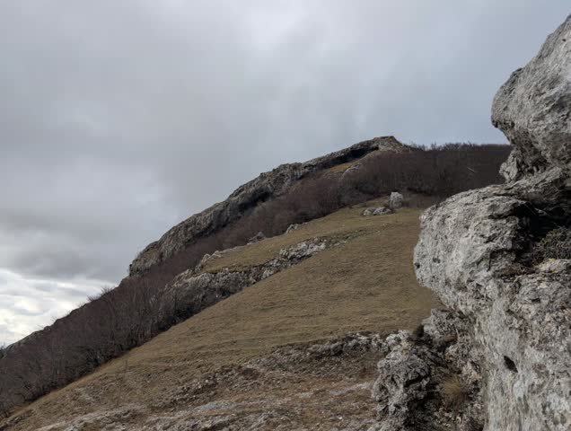 Mountain landscape with rocky slopes and cloudy sky, natural and wild atmosphere