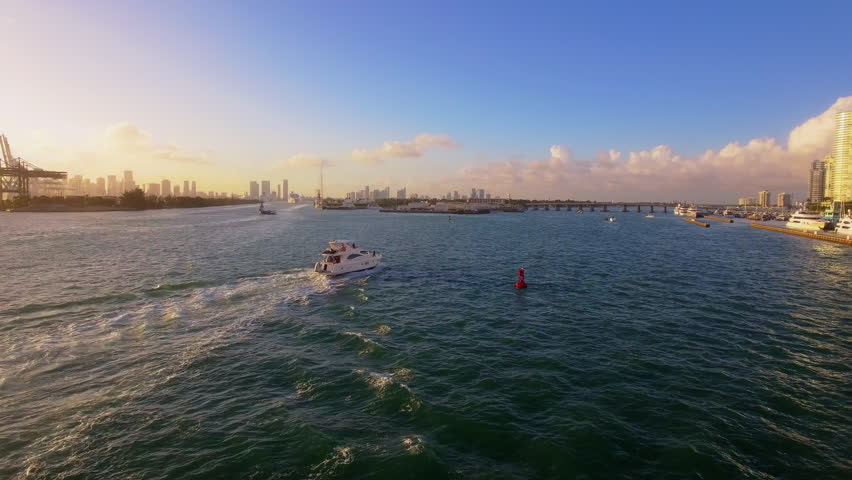 Static drone view of a boat passing a red buoy in Biscayne Bay at sunset.