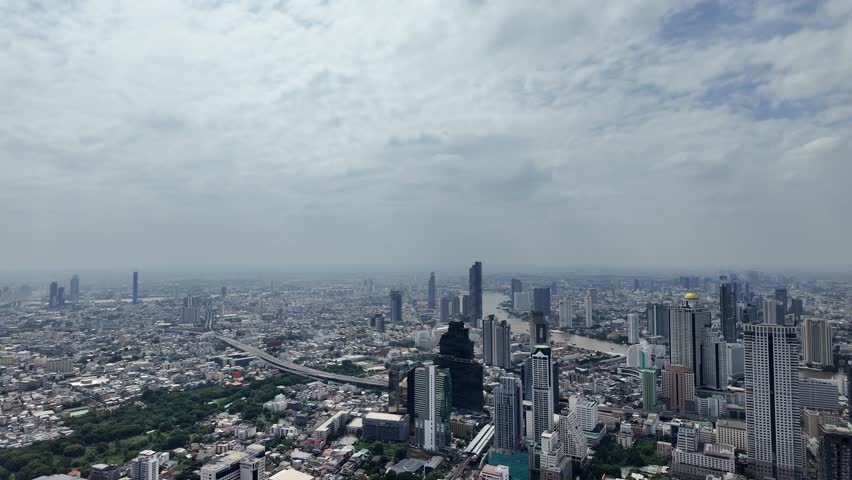 aerial panorama of bangkok cityscape with skyscrapers and chao phraya river under cloudy sky