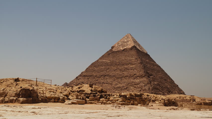 Wide view of the Great Pyramid of Giza in Egypt, showing ancient stone blocks, desert landscape, and clear sky, symbolizing early civilization, history, and architectural achievement.