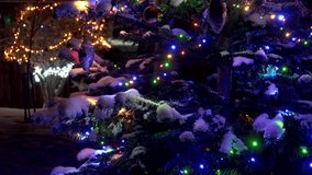 Close-up of a snow-covered Christmas tree branch at night. Colorful LED lights shine, illuminating ornaments and fresh snow. Multicolored bokeh fills the background. A magical festive atmosphere. - Powered by Shutterstock - Get 15% off with code: PIKWIZARD15