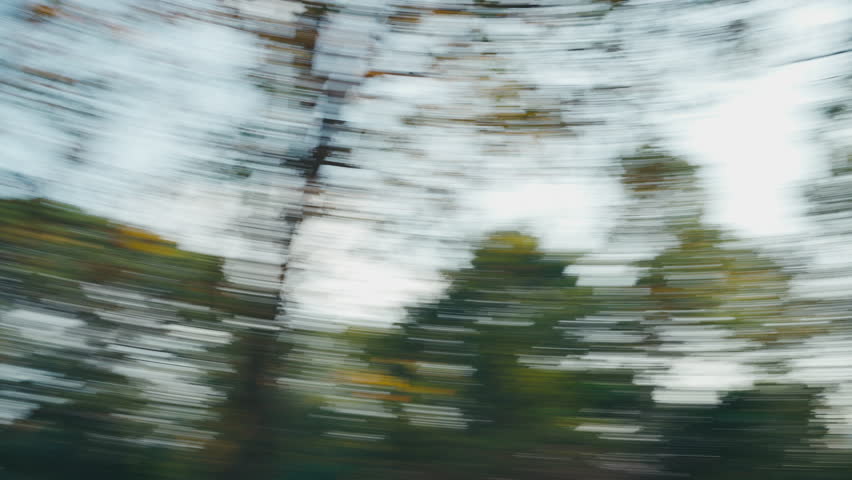 Whip pan motion blur of green trees and grass in a public park for video transition