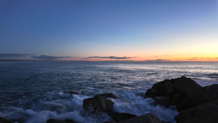 Open Atlantic ocean with gentle waves and distant horizon under soft dusk sky, peaceful seascape with fading sunlight
