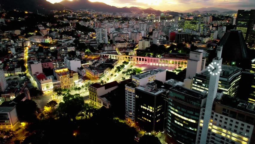 Sunset aerial view of downtown Rio de Janeiro, Brazil. Panoramic cityscape with famous urban landmarks glowing at golden hour, showcasing the vibrant capital city and popular tourism destination in South America.