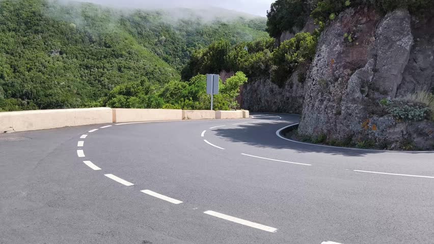 Steep hairpin bend on TF-12 mountain road, Anaga, Tenerife. Camera pans smoothly left to right.