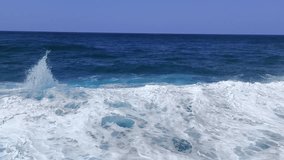 Slow motion ocean waves roll in with bright foam. Deep blue water swirls under a clear sky near the horizon. - Powered by Shutterstock - Get 15% off with code: PIKWIZARD15
