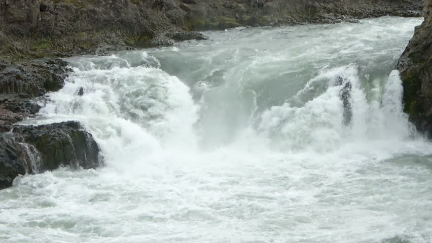 Raging whitewater flowing over rocks in a powerful Icelandic river creating a majestic cascade