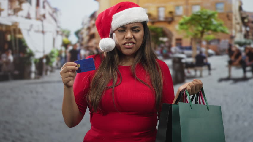 Plus size woman holds creditcard in one hand and shopping bags in the other on a busy street; holiday shopping frustration.