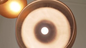 close-up of modern gold-finished ceiling lamps with warm ambient light - Powered by Shutterstock - Get 15% off with code: PIKWIZARD15