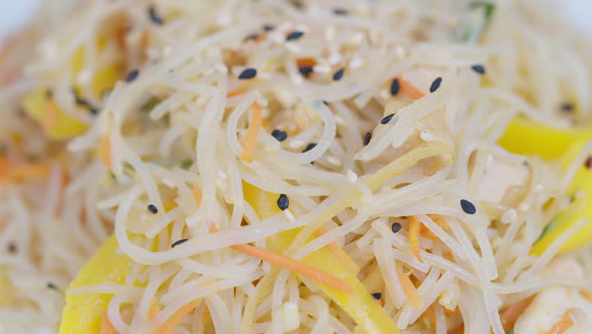 Vivid noodle dish. Brightly colored vermicelli with fresh vegetables and light dressing. Vibrant summerinspired rice noodle salad with crunchy carrots and citrus flavor