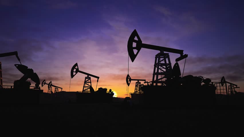 This compelling aerial video captures the relentless rhythm of an active oil field, where numerous pumpjacks and beam pumps operate in unison across a vast industrial landscape. Under a dramatic, time-lapsed sky, these iconic machines methodically extract crude oil, showcasing the scale, power, and ongoing nature of fossil fuel energy production and industrial might.