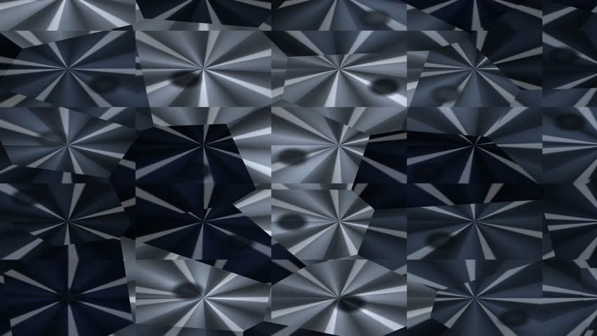 A close-up of a metallic geometric pattern with a reflective surface, showcasing a repeating design of sharp, angular shapes.