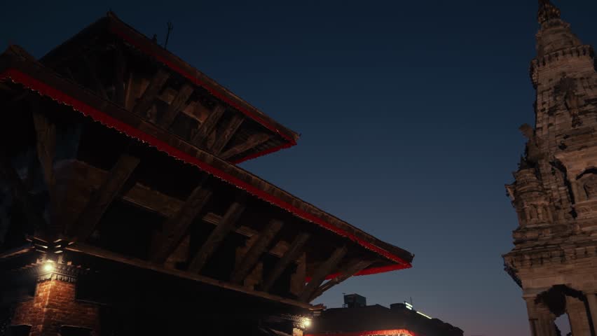 Traditional historic pagoda temples around Bhaktapur Durbar Square as evening lights turn on. Nepal